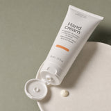 Crema Manos y Uñas 75 ml. Detalle de apertura y textura del producto.